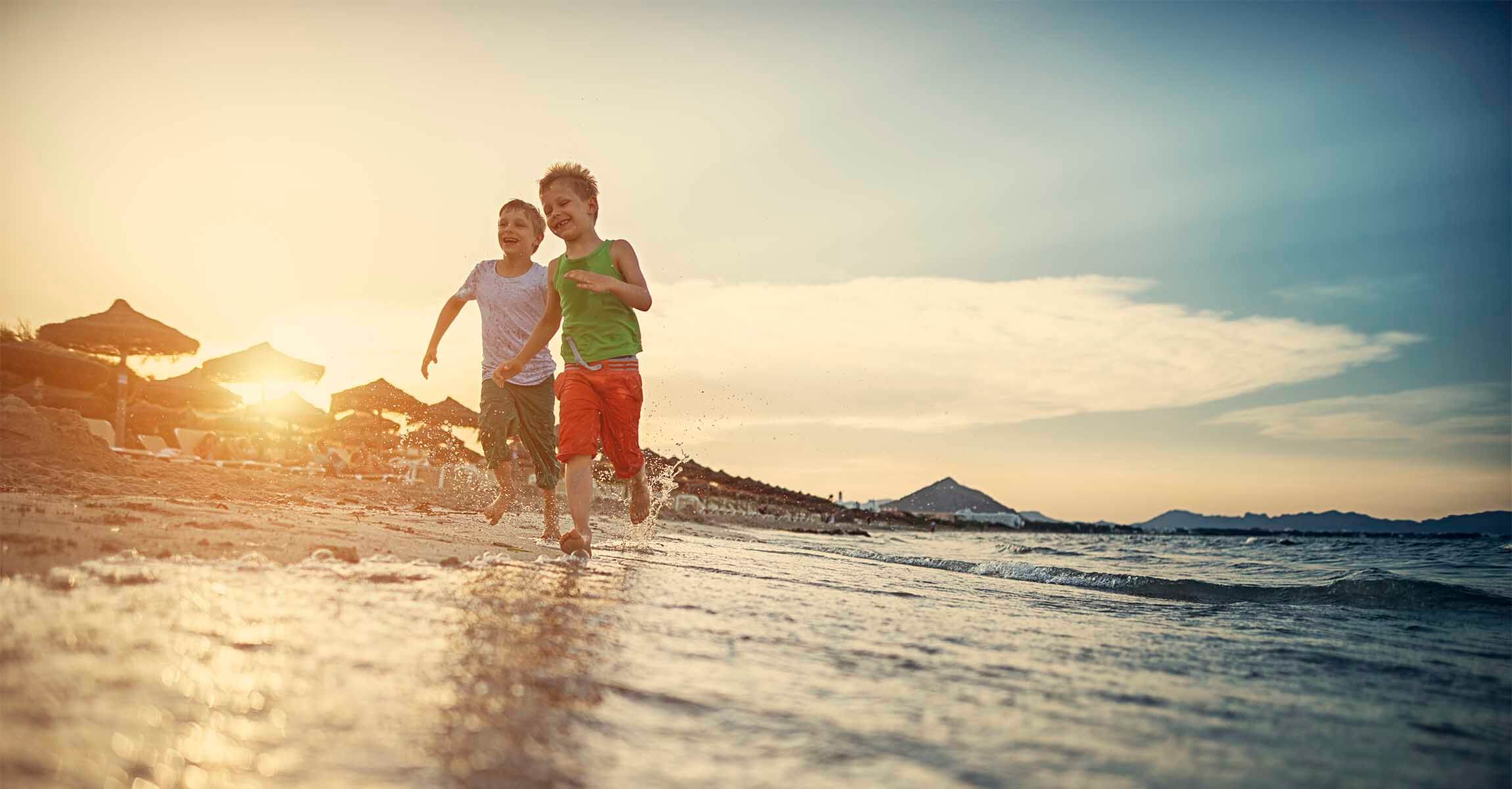 Two boys running on the beach