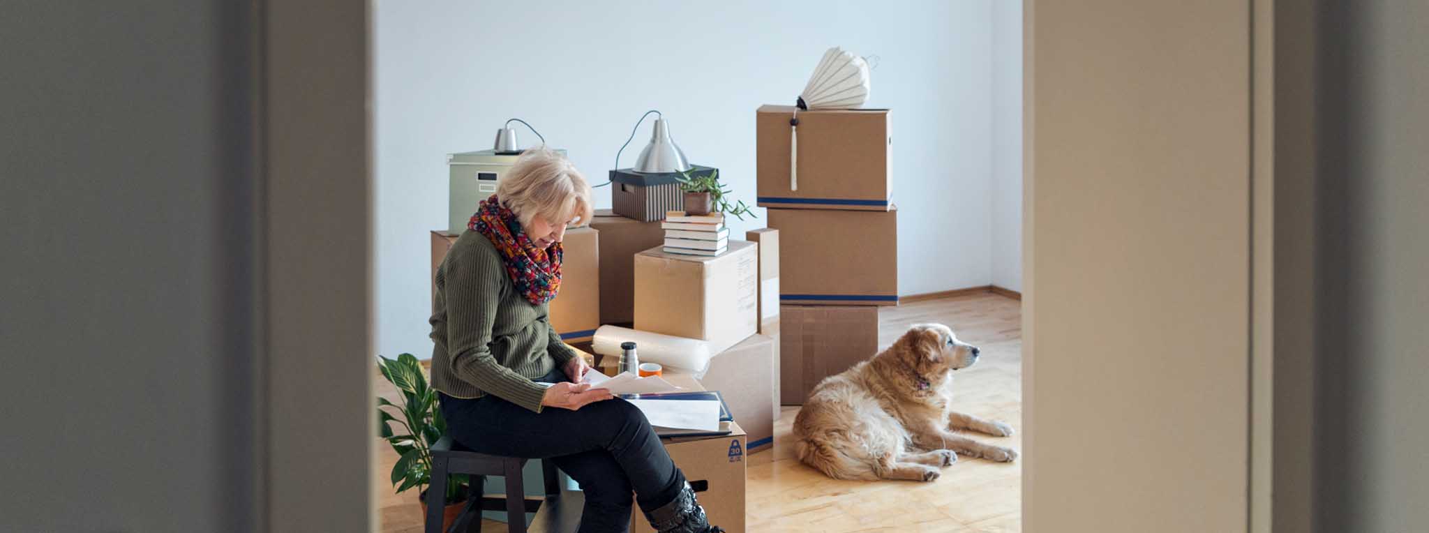 woman with dog sitting with boxes