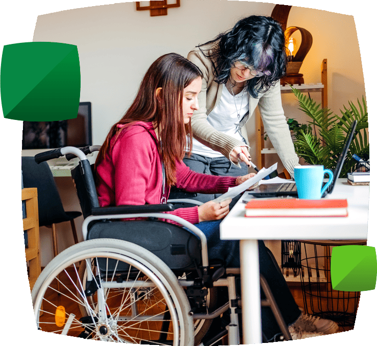 young woman in wheelchair looking at paperwork with friend