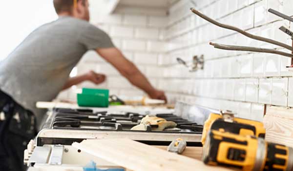 person tiling kitchen