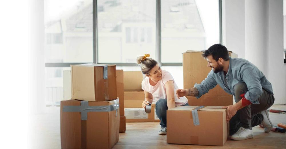 couple sealing boxes with packing tape